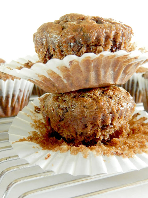 Side view of chocolate banana muffins unwrapped on a cookie rack.