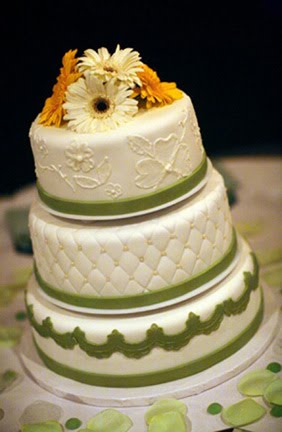 Delicate quilted three tier wedding cake with orange and white gerbera 