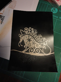 Black card with image of gold sleigh stamped and embossed