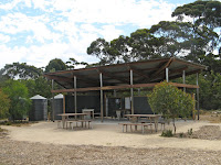 Campground facilities on the Kangaroo Island Wilderness Trail are good. Each campground has a communal kitchen and dining shelter like this one, with 4 picnic tables, a dishes and food prep area and filtered water.