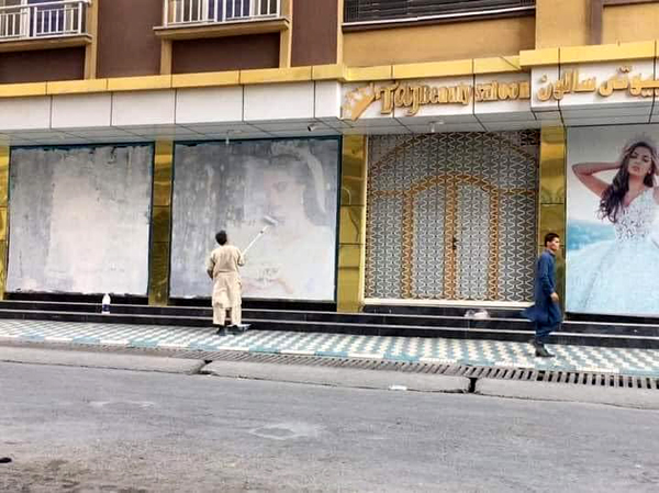 Advertisements featuring female models are painted over on storefront windows in Kabul, Afghanistan...on August 15, 2021.