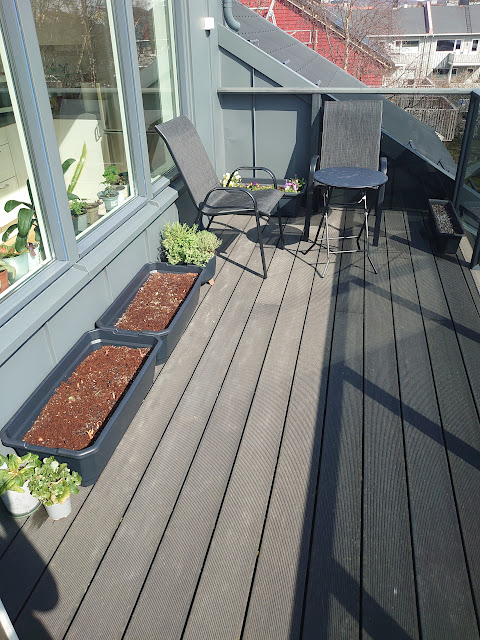 Terrasse med hagemøbler og plantekasser