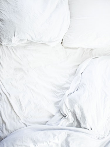 Messy bed with white sheets