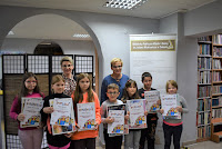 Dzieci - laureaci konkursu pozują do zdjęcia z otrzymanymi dyplomami.