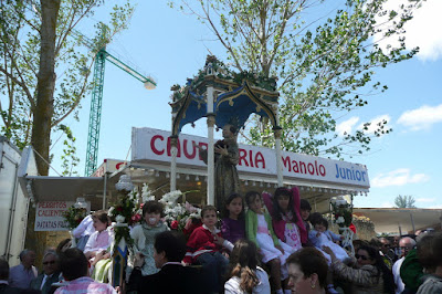 Procesión del santo Regalado por la pradera. En primer lugar la carroza con los niños subidos en ella, en el fondo un puesto de churros. baldaquino deg