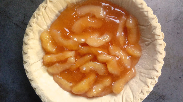 apple pie filling sitting in a frozen pie crust