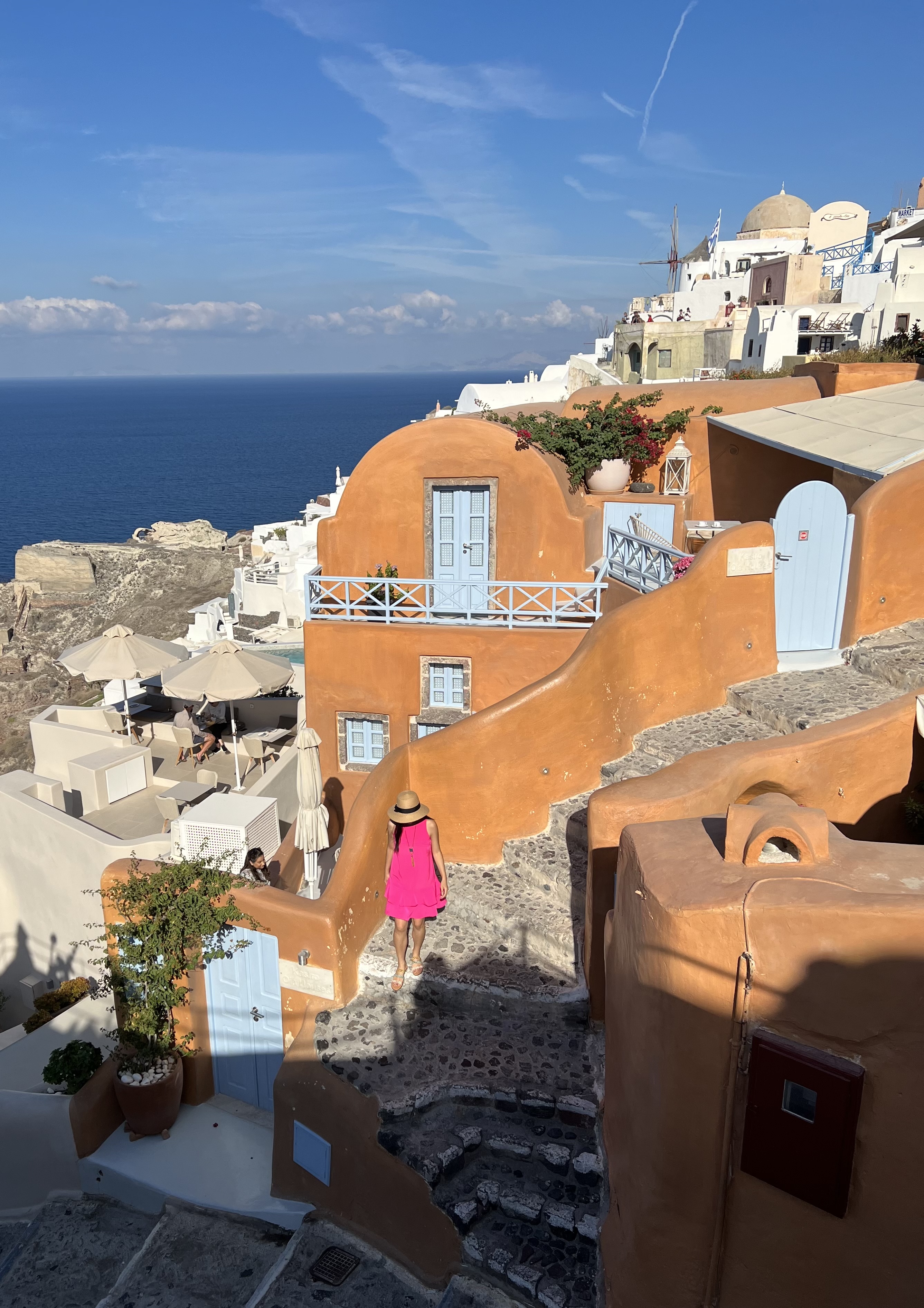 Sisterhood of the Traveling Pants_Kastro Oia Hotel_Orange Hotel in Santorini_Pink Dress and Fedora_Vacation Destination_adrienne Nguyen