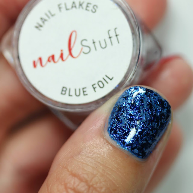 Blue Metallic Nail Flakes from NailStuff shown over blue nail polish on one nail 