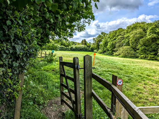 Go through the gate then head diagonally across a field
