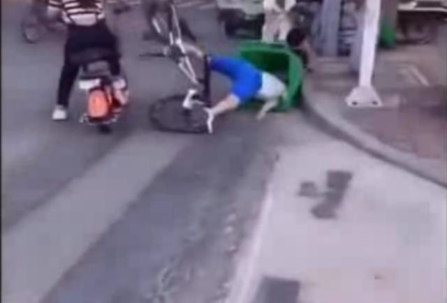 Chàng trai cắm đầu vào thùng rác vì mải ngắm người đẹp trên phố