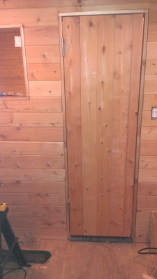 Built from scratch sauna door is installed with an air gap below for fresh air.