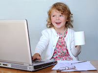 child in business suit with cup of coffee sitting at computer