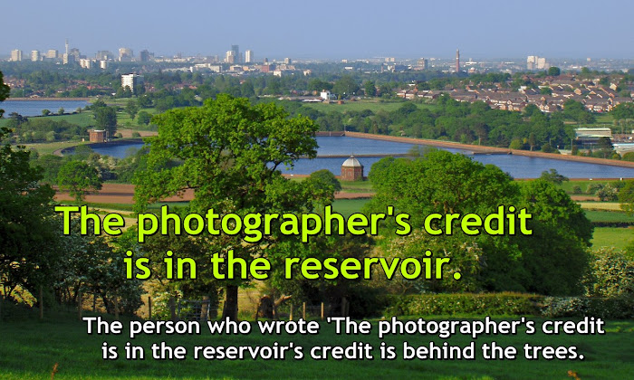 Vista comprising reservoir and trees, with text - The photographer's credit is in the reservoir. The person who wrote 'The photographer's credit is in the reservoir's credit is behind the trees.