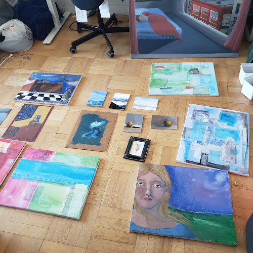 several different paintings layed out on the floor