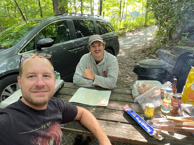 Andy and Dad sitting at a picnic table across from each other at their campsite.