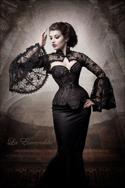 Woman wearing neo-victorian clothing. Black overbust longline corset, skirt and lace bolero.