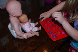 Preschooler using Play Doh to make pretend cookies for her dolls