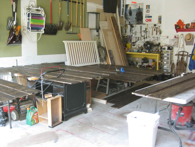 garage full of planks of plywood for flooring