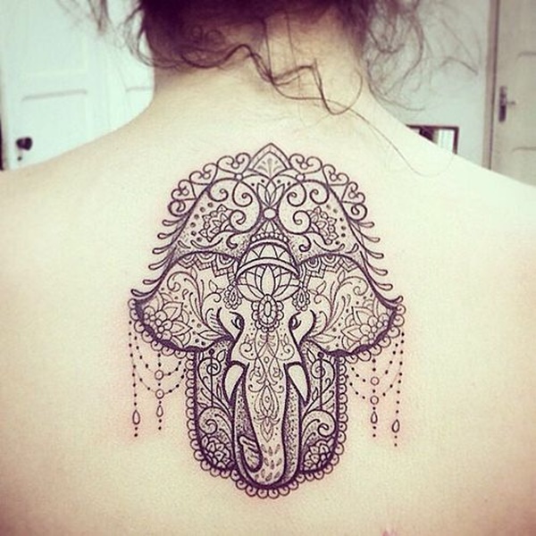 Um elefante é embelezado com uma mandala padrão e suspensão de contas em preto tatuagem prestados no meio do utente na parte superior das costas.