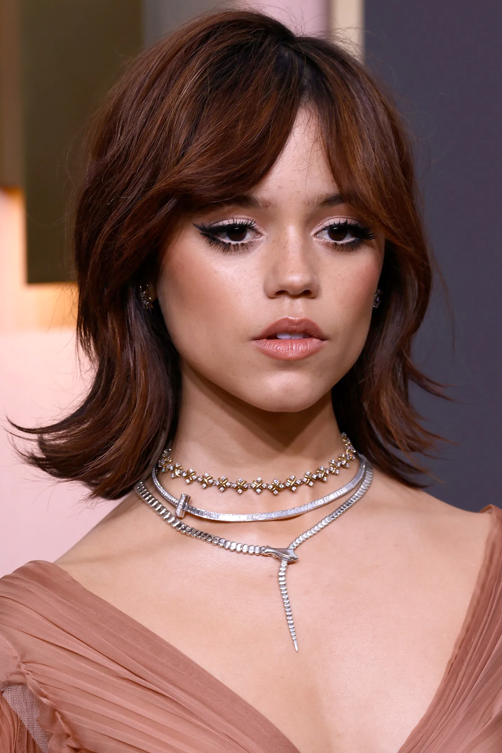 jenna ortega with Bottleneck Bob hair and Choppy Ends posing to the camera on a red carpet