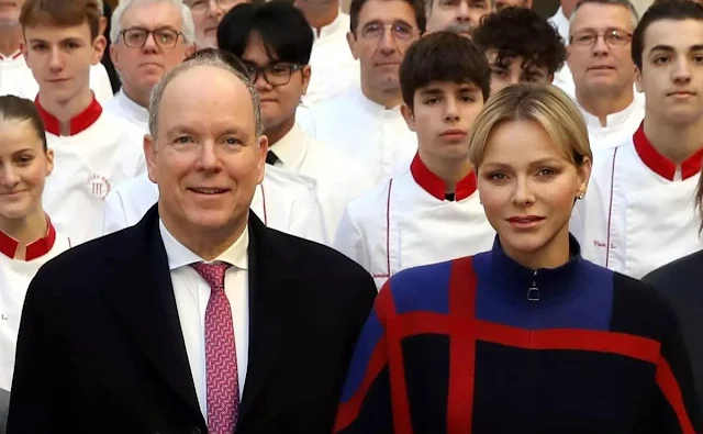 Princess Charlene wore a cashmere double-face glen check cape by Akris, and diamond earrings. Princess Gabriella and Prince Jacques
