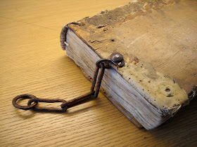 A photograph of a book with a few chain links attached to its edge.
