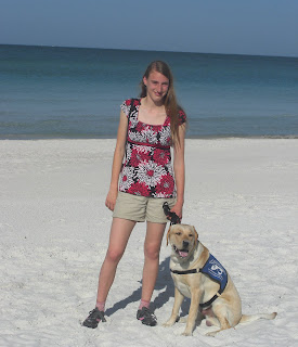 Picture of Toby & I on the beach, Toby is in a sit-stay wearing his coat. (also note that the shirt I'm wearing is the same one as when I first met Toby