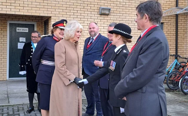 Queen Camilla wore a camel suede coat and silk blouse and printed skirt. The Queen visited Deacon and Son jewellery shop