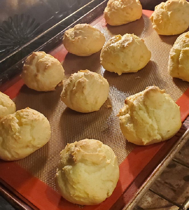 a sheet pan of cream puffs cooling