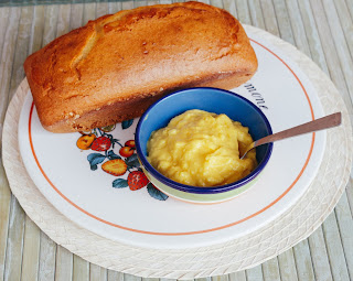 foto di crema pasticciera fatta in casa su superficie rustica, per accompagnare torta plumcake adagiata su piatto portatorte.