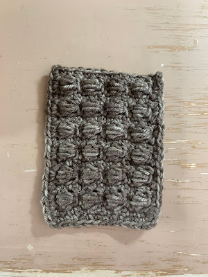 picture of a crocheted wall for the hut with raised bumpy stitches to resemble rocks.