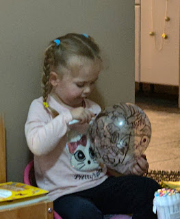 Drawing all over her balloon