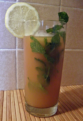 Glass of iced tea garnished with lemon and mint