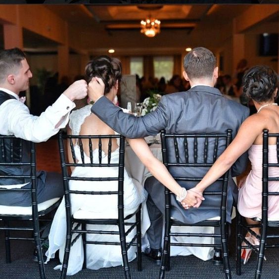 K'Mich Weddings - wedding planning - grooms check list - bridal party sitting at the table with holdings hands behind them