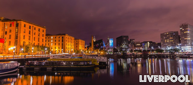 Liverpool's docks at night with lights from the city reflecting on the water