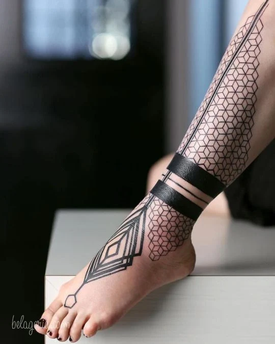 vemos una pierna con tatuajes geometricos