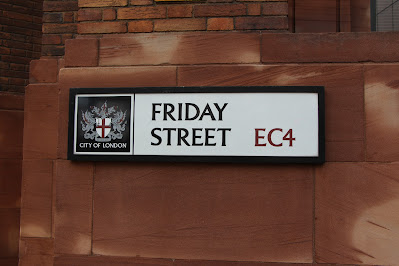 Sandstone wall in London with a street sign that says Friday Street  EC4 and also has the City of London coat of arms on it.