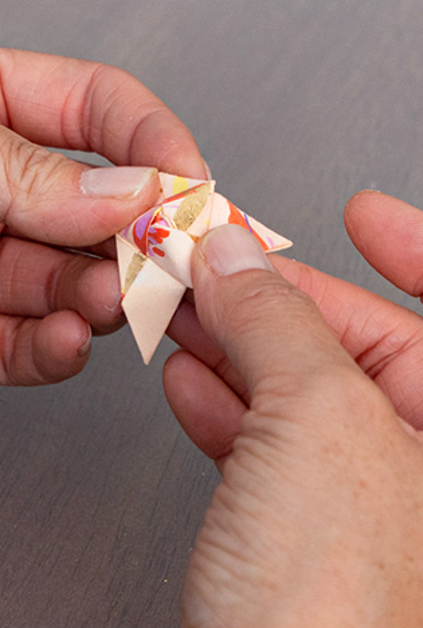 hands folding patterned paper origami unit