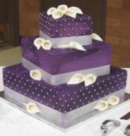 This is a three tiered square wedding cake iced in royal puple buttercream