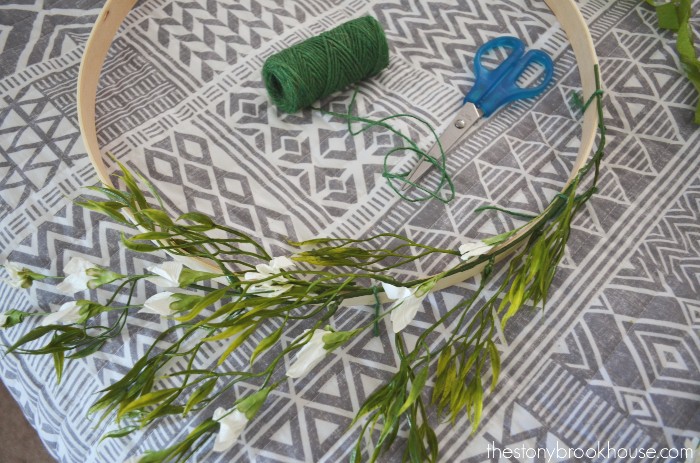 Tie greenery to embroidery hoop