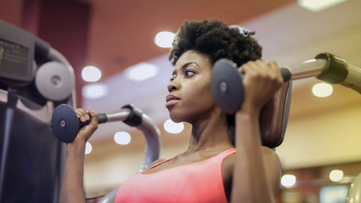 Woman in Pink Sport Bra Sitting on Exercise Equipment