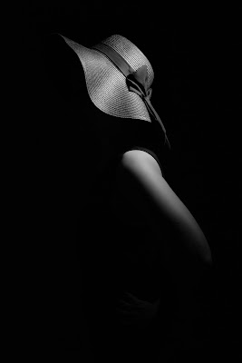 black and white photo of dark silhouetted woman in 1920s floppy hat