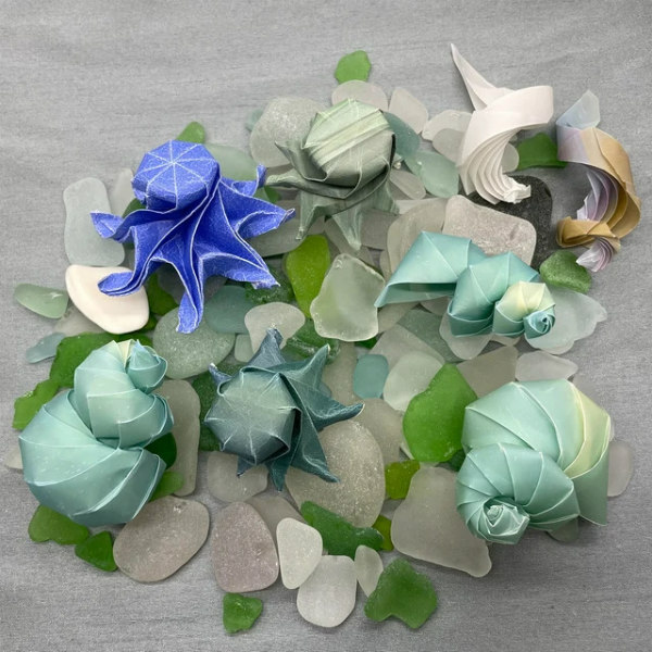 origami sea creatures in shades of blue and green displayed with sea glass