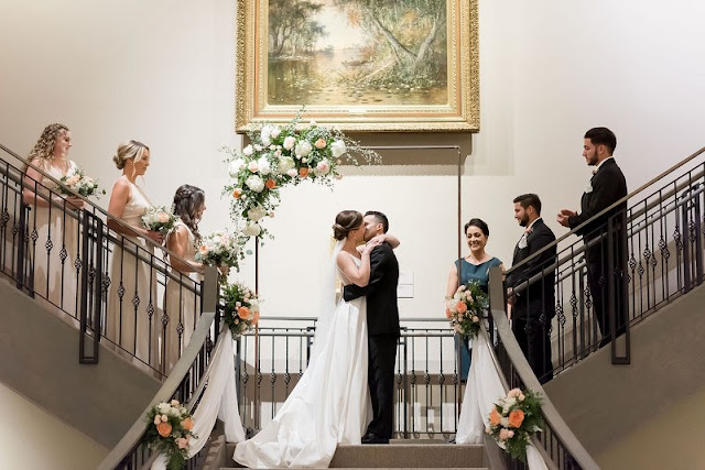 bride and groom kissing at ceremony altar on top of the stairs