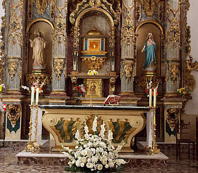 Altar com as hóstia na ambula de cristal.