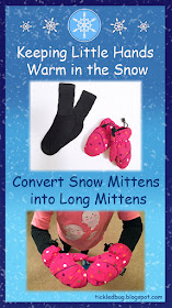 Blue background with snowflakes and child wearing pink polka dot snow mittens