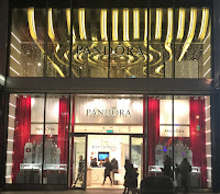 Pic of outside of Pandora's store in gold, silver and red.