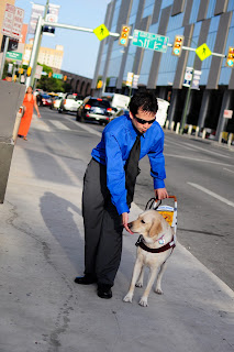 Darrell and Egypt walking down the sidewalk, you can see the street and overhead signs behind them.