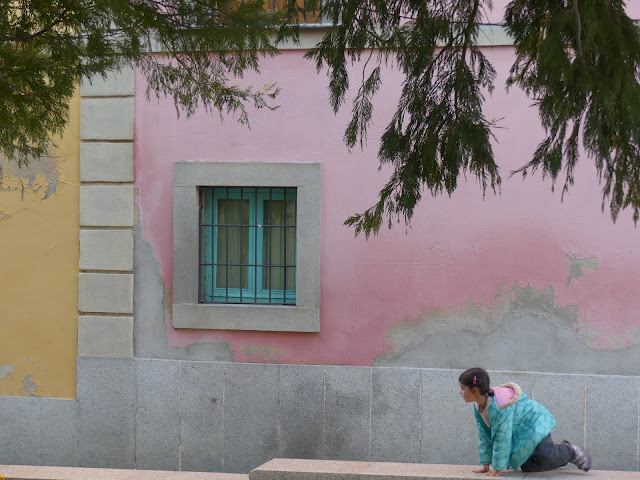 Fachada rosa con niña agachada