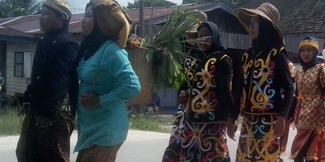 Menggunakan pakaian tradisional